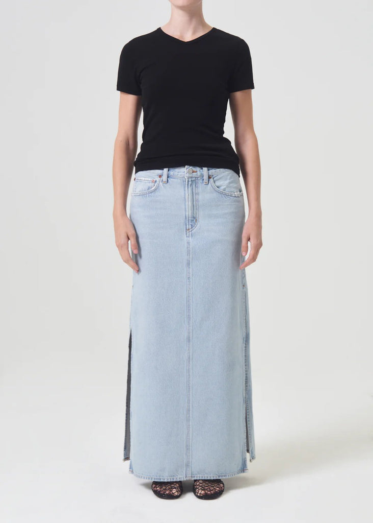 Agolde astrid slice skirt in fragment, light wash denim. Styled on model wearing a black t-shirt. 