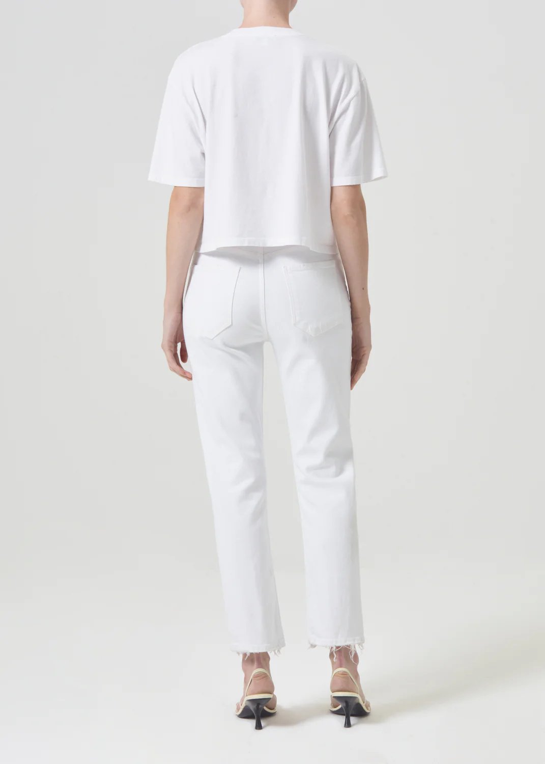 agolde women's riley high rise straight crop denim in sour cream. Model is wearing monochromatic outfit. Behind view.