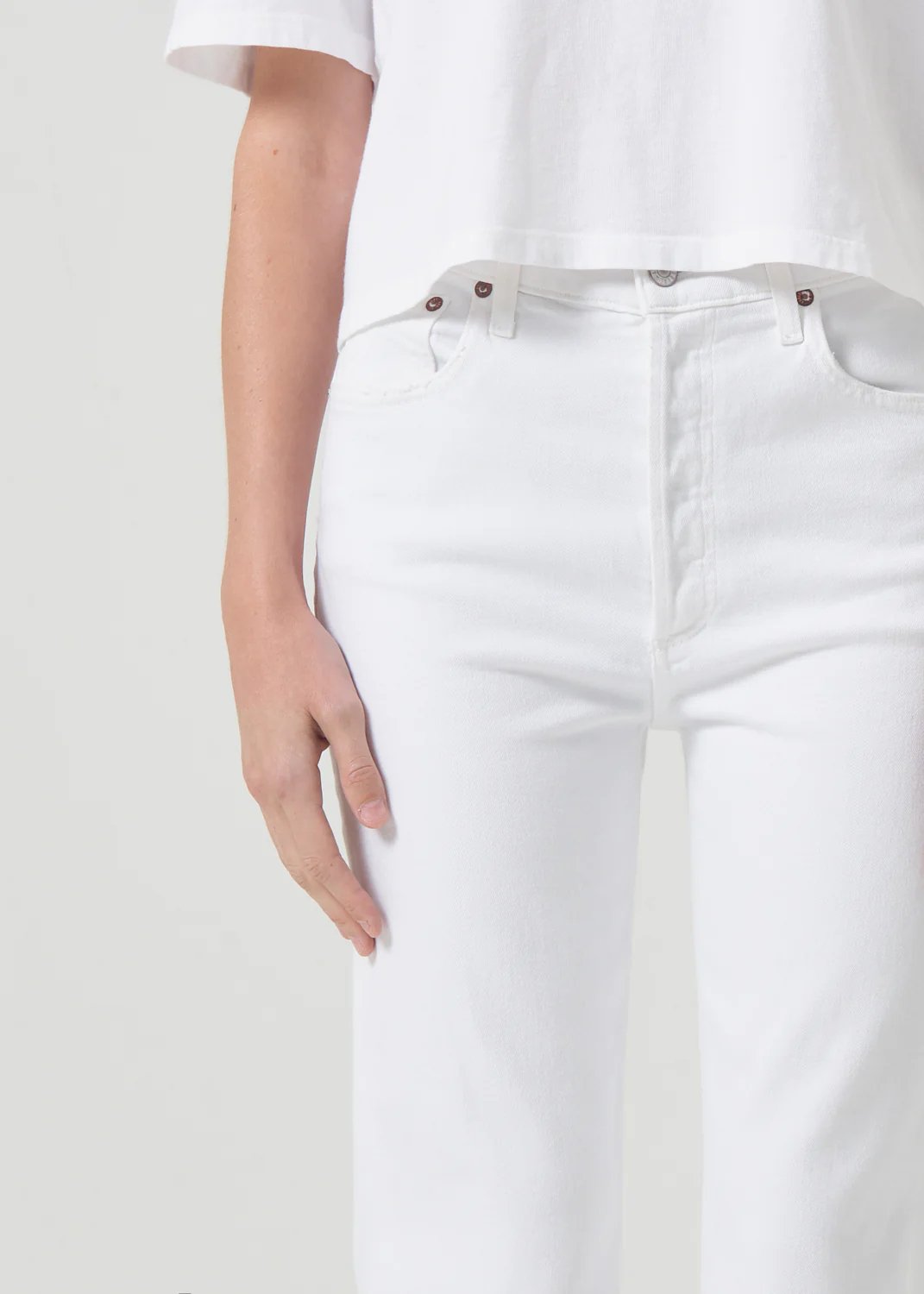 Up close view of agolde women's riley high rise straight crop denim in sour cream. Model is wearing monochromatic outfit.