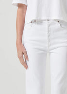 Up close view of agolde women's riley high rise straight crop denim in sour cream. Model is wearing monochromatic outfit.