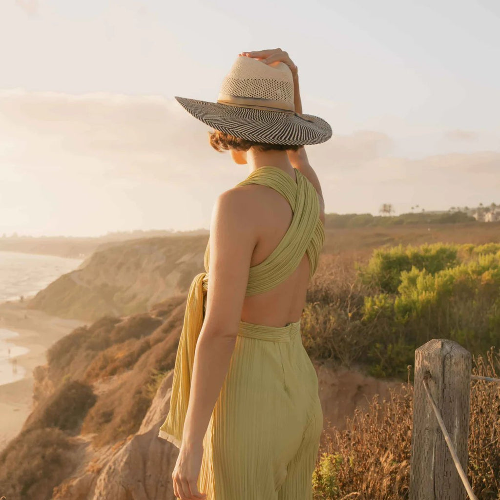 Freya Mesquite, vented natural crown paired with upturned cowgirl brim in black and natural, trimmed with hand-dyed cotton ribbon. Styled on model on hill by ocean during sunset.