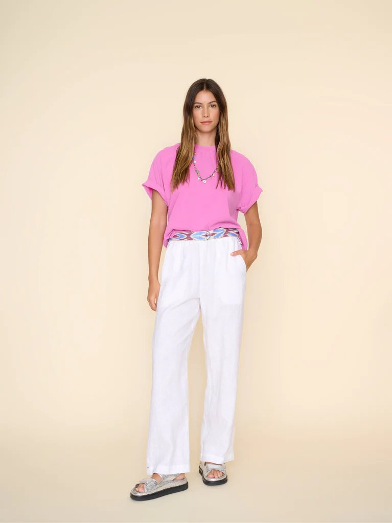 xirena atticus pant in white worn on model with silver sandals and a pink tshirt